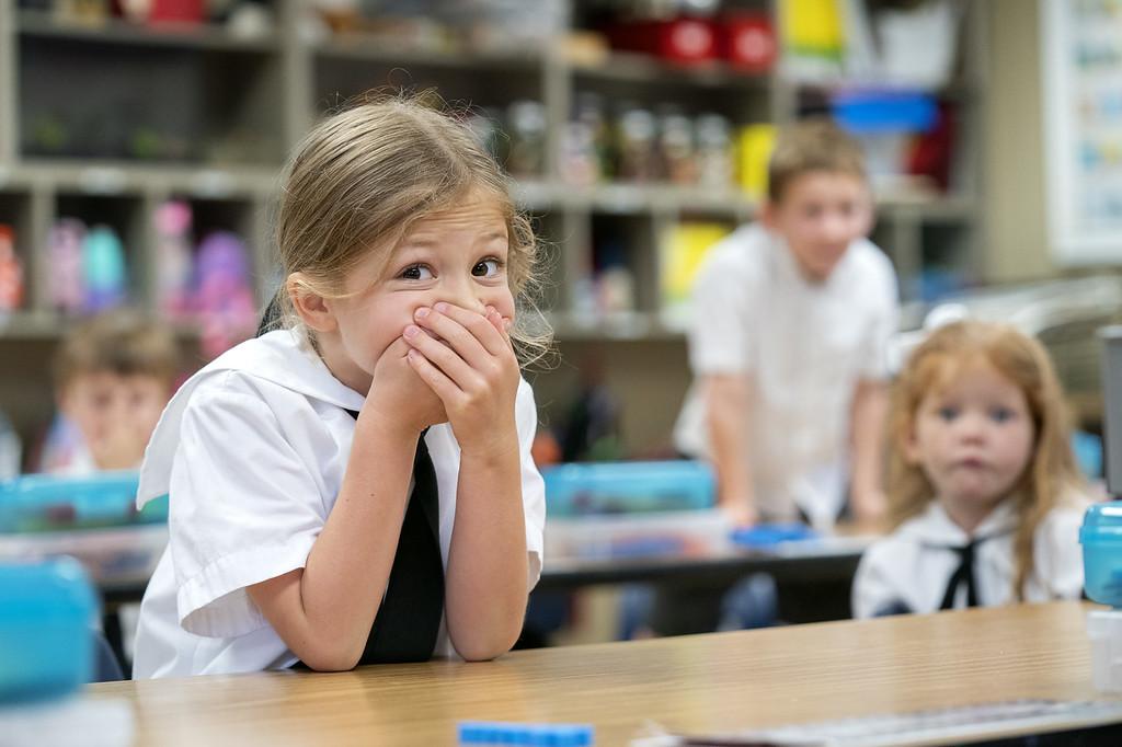 young girl covering mouth